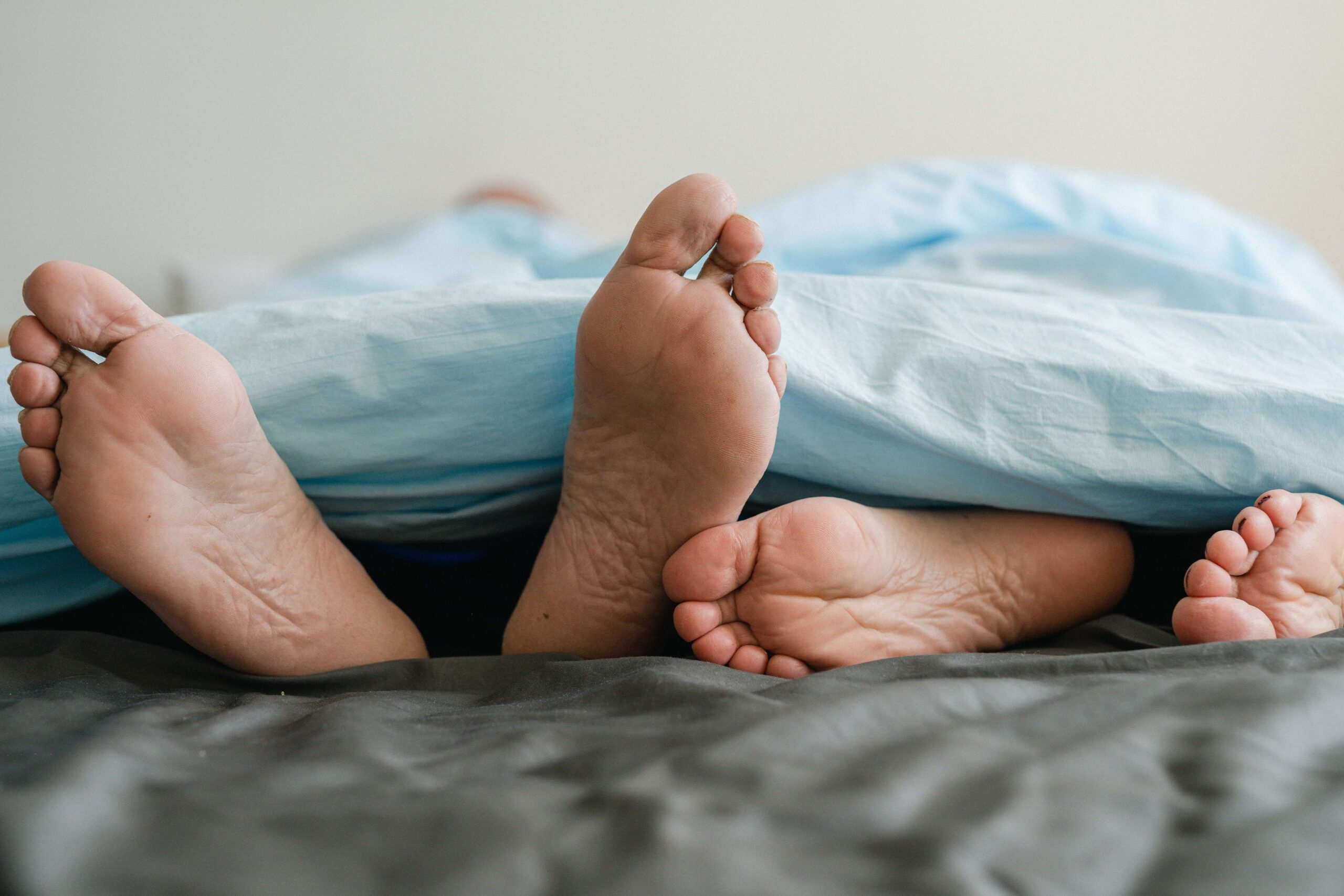 Personnes allongées dans un lit, évoquant la vie intime du couple
